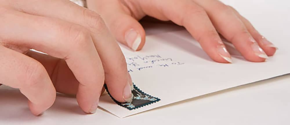 Briefmarken kleben: Unser Lettershop versieht Mailings auf Wunsch mit echten Briefmarken.